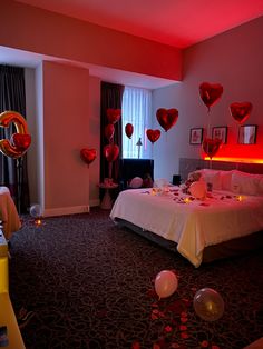 a bedroom decorated for valentine's day with heart balloons