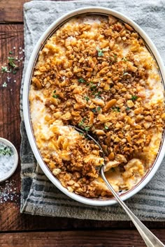 a casserole dish filled with meat and cheese on top of a wooden table