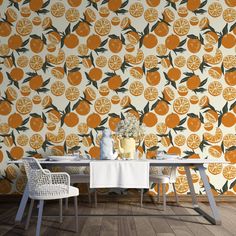 an orange wallpaper with white table and chairs