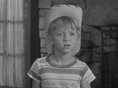 a young boy with a paper hat on his head