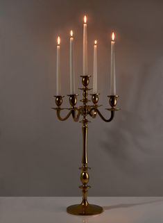 a golden candelabra with five candles lit