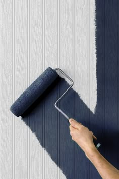 a person using a paint roller to paint a wall