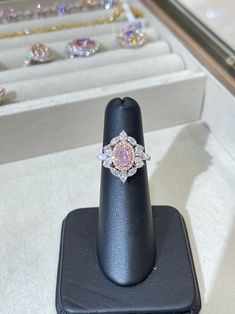 This 1 Carat Oval is a beautiful and feminine piece of jewelry that exudes grace and sophistication. The oval cut adds an elongated and elegant look to the ring, while the pink color adds a touch of romance. Pink diamonds are rare and highly coveted, making this ring a unique and valuable addition to any jewelry collection. Ring Details: 1.00 Carat Very Light Pink Oval SI2 Clarity Set in 18k White & Rose Gold Set with an additional 1.65 carats of side white and pink diamonds. Size 6 Formal Pink Halo Design Ring, Luxury Pink Oval Diamond Ring, Oval Pink Gia Certified Diamond Ring, Gia Certified Oval Pink Diamond Ring, Elegant Pink Morganite Diamond Ring, Elegant Pink Gia Certified Diamond Ring, Elegant Gia Certified Pink Diamond Ring, Pink Morganite Diamond Ring, Elegant Style, Formal Pink Gia Certified Diamond Ring