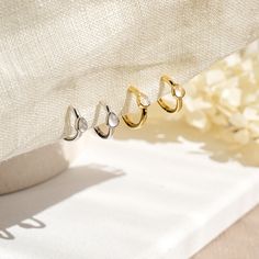 A pair of delicate Moonstone mini huggie hoop earrings in 14k yellow gold or white gold plated 925 sterling silver. These minimalist dainty earrings feature a small natural moonstone hoop.  Stack these gold moonstone earrings with -  Starburst opal hoop earrings: https://www.etsy.com/uk/listing/1341094262/genuine-opal-star-hoop-earrings-in-14k Moonstone gold necklace: https://www.etsy.com/uk/listing/1181311651/natural-moonstone-star-necklace-in-14k Moonstone gold ring: https://www.etsy.com/uk/li Delicate White Gold Huggie Earrings For Anniversary, Dainty Huggie Earrings For Anniversary, Dainty White Gold Hoop Earrings, Delicate White Hypoallergenic Huggie Earrings, Dainty Tarnish-resistant Cartilage Earrings For Anniversary, White Delicate Huggie Earrings For Gift, Delicate White Huggie Earrings As Gift, Delicate White Huggie Earrings For Gift, Dainty White Hypoallergenic Huggie Earrings