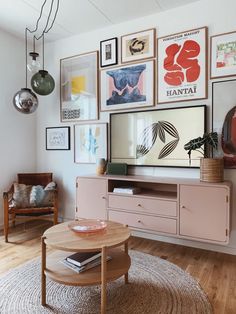 a living room with pictures on the wall and a coffee table in front of it