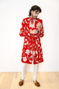 Make a lasting impression in our BRIJ Red and White Wedding Sherwani. Made with a beautiful embroidered dupioni, this sherwani features a stunning white and gold floral pattern for a modern twist on a classic Indian groom look. The perfect choice for a sophisticated but bold Indian groom. Details Thread and Sequin Embroidered 100% Polyester Dupioni Lined in Crepe-back Satin Dry Clean Only Item #102601-24-04 Made in NYC - Ethically designed + produced in New York City Red Sherwani With Intricate Embroidery For Reception, Red Embroidered Sherwani For Reception, Wedding Sherwani With Floral Embroidery In Traditional Drape, Wedding Bollywood Sherwani With Dori Work, Bollywood Wedding Sherwani With Dori Work, Wedding Sherwani With Floral Embroidery And Traditional Drape, Wedding Sherwani With Floral Embroidery, Wedding Red Bandhgala With Long Sleeves, Festive Sherwani With Dori Work For Reception