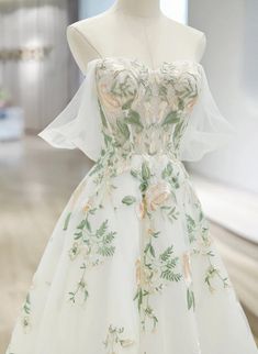 a white dress with flowers and leaves on it