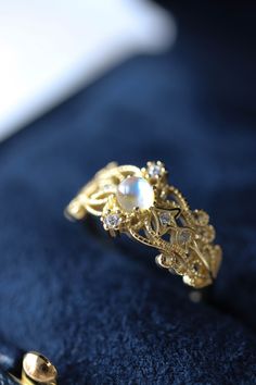 Sonia Moonstone Floral Gold Lace Filigree 18K Gold Vermeil Ring features moonstone in the centre, accented by lace filigree on the sides. It is similar to Monique Moonstone Ring in our shop, but the details of the ring are different. This is an adjustable ring, it comes in one size only and fits US ring size 5 to 8. ◊ 18K Gold Vermeil ◊ Adjustable Ring ◊ Sold in ONE SIZE only ◊ Fits US ring size 5 to 8 ◊ Lab Moonstone and cubic zircons ◊ Delivered in our signature royal blue box, it makes the pe Gold Moonstone Crystal Ring, Celestial Gold Moonstone Ring, Gold Celestial Moonstone Ring In 14k, Gold Moonstone Ring As Gift, Gold Moonstone Crystal Ring For Anniversary, Gold Moonstone Ring With Accent Stones For Promise, Gold Moonstone Ring For Gift, Elegant Moon-shaped Promise Ring Jewelry, Delicate Gold Moonstone Ring Gift