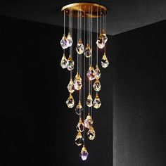 a chandelier hanging from the ceiling in a room with black walls and flooring