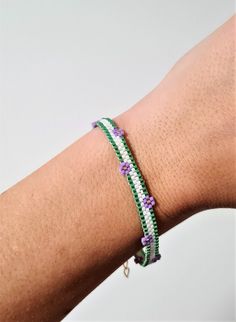 a woman's arm wearing a bracelet with beads on it and a beaded clasp