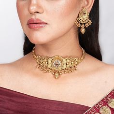 India Necklace Antique Gold Choker with Ruby Kundan embodies the essence of South Indian jewelry, reminiscent of Amrapali's iconic designs. This temple-inspired statement piece, perfect as a Bollywood wedding gift, radiates traditional elegance and cultural heritage. Ideal for her special occasions, it celebrates craftsmanship and timeless allure. *𝐏𝐑𝐎𝐃𝐔𝐂𝐓 𝐃𝐄𝐓𝐀𝐈𝐋* * Material: Brass * Plating: Gold Plated * Stone: Semi Precious Stones.  *𝐃𝐈𝐌𝐄𝐍𝐒𝐈𝐎𝐍𝐒* * Necklace:- Weight: 56 22k Yellow Gold Chandbali Kundan Necklace, 22k Gold Chandbali Necklace With Cutdana, 22k Gold Jewelry Sets For Diwali, Celebration 22k Gold Temple Necklace With Meenakari, Bollywood Style Yellow Gold Bridal Necklace For Diwali, 22k Gold Jewelry Sets For Festive Celebrations, Festive Bridal Necklace With Zari Work As Gift, Traditional Gold Plated Bridal Sets For Celebration, Festival Choker With Zari Work For Gift