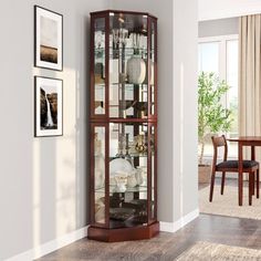 a tall red curio cabinet sitting in the corner of a room