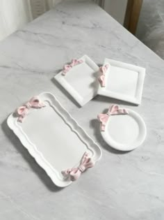 white plates with pink bows on them sitting on a marble counter top next to a plate