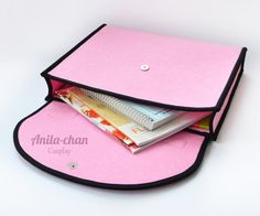 a pink and black purse with two stacks of money in the bottom half, on top of each other