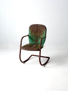 an old chair is sitting on a white surface with no one around it and the seat has been rusted