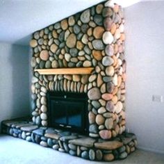 there is a stone fireplace in the corner of this room with no one around it