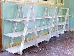 three white wooden shelves sitting next to each other in front of a mirror on the wall