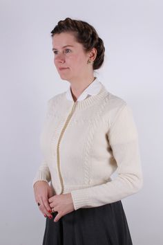 This 1940s / 1950s-style cardigan, crafted from 100 % merino wool with cable patterns, features a round neckline, a fitted waist and chest, and seven acrylic buttons for closure. The slim-fitting sleeves boast ribbed edges and a short shoulder-to-hemline length for a flattering silhouette. This stylish piece pairs well with day dresses, high-waisted skirts, and trousers and is constructed with Italian-made, luxuriously soft yarn. The yarn is super soft and made in Italy. Available in sizes XS, S 1930s Shoes, 1950s Shoes, 1920s Shoes, 1940s Shoes, Vintage Style Shoes, Vintage Knitwear, Winter Fashion Boots, Edwardian Fashion, Stiletto Sandals