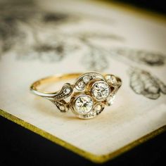 an antique diamond ring sitting on top of a book