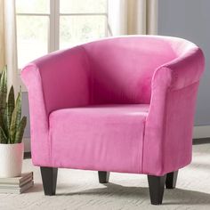 a pink chair sitting next to a potted plant