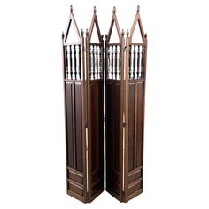 three tall wooden doors with metal railings on each side and an open door at the top