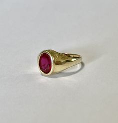 Amazing vintage 14k yellow gold created ruby ring, circa 1960s! The created red ruby weighs an estimated 1.21 carats, is oval cut, and is a stunning deep red. The setting contains a classic design with a high polish finish. Classic statement piece of fine retro jewelry showcasing a stunning created ruby, circa 1960s! ERA - Circa 1960s, Retro METAL / MATERIAL - 14k yellow gold, 1 created ruby (estimated 1.21 carats) [Synthetic ruby contains essentially the same chemical composition & properti Yellow Gold Ruby Signet Ring With Polished Finish, Classic Red Ruby Ring In 14k Gold, Heirloom Red Gold Signet Ring, Classic Red Signet Ring Stamped 14k, Vintage Red Signet Ring Stamped 14k, Classic Oval Ruby Ring In Yellow Gold, Classic Gold Ruby Signet Ring, Classic 14k Gold Red Signet Ring, Timeless Polished Ruby Ring