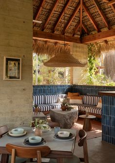 an outdoor dining area with blue and white striped cushions, wooden tables, and chairs