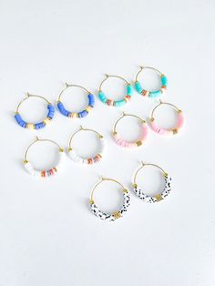 six pairs of hoop earrings with tassels and beads on the ends, all in different colors