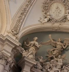 an ornately decorated ceiling in a building with statues on the walls and around it