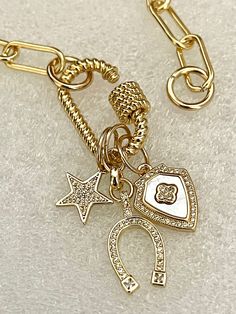 This necklace features an open-link paperclip chain with 14k gold plating. The chain is electroplated Brass for durability. 3 gorgeous charms attached. The Charms hang on a gold-plated carabiner rope design screw clasp and are interchangeable. Beautiful layering necklace! 1. CZ micro pave Star Charm. 2. CZ micro pave Horseshoe Charm 3. CZ micro pave and Mother of Pearl Crest Charm with a Clover center Available in many lengths. Please choose length from drop down menu Tips to keep your jewelry l Clean Packaging, Clover Charm, Rope Design, Layering Necklace, Keep Jewelry, Star Charms, Micro Pave, Physical Activities, Paper Clip