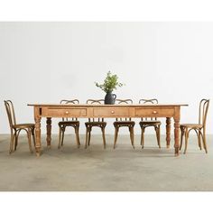 a wooden table with chairs and a potted plant sitting on it's side