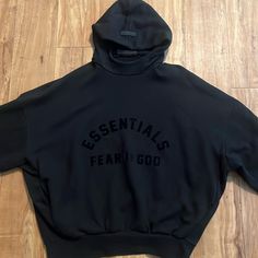 The Fear Of God Essentials Hoodie Provides Volume In The Body And Sleeves With The Intent Of Creating A Soft, Round, Cropped Silhouette. A Mock Neckline And Side Seam Pockets To Provid Fall Athleisure Hoodie With Logo Print, Fall Hooded Top With Logo Print, Logo Print Hoodie For Fall, Black Funnel Neck Sweatshirt With Drawstring Hood, Black Funnel Neck Sweatshirt For Streetwear, Black Hoodie With Funnel Neck For Streetwear, Black Hoodie With Ribbed Cuffs And Funnel Neck, Black Oversized Hoodie With Funnel Neck, Black Oversized Funnel Neck Hoodie