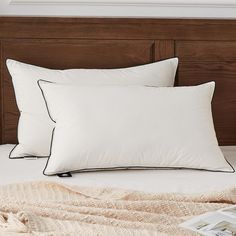 two white pillows sitting on top of a bed