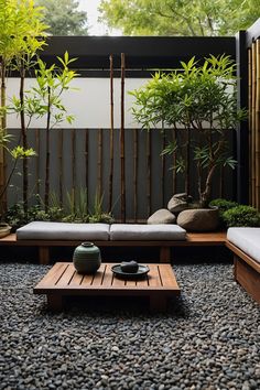 a living room with some plants and rocks on the ground in front of a bamboo fence