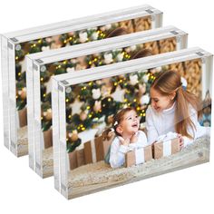 three clear acrylic photo frames with christmas tree and presents in the back ground