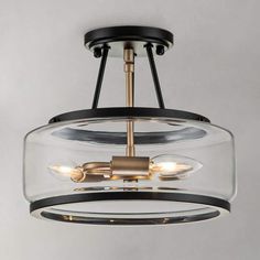 a glass and metal light fixture with two lights on each side, hanging from the ceiling