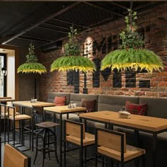 an empty restaurant with wooden tables and chairs covered in green plants hanging from the ceiling