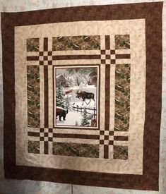 a quilt hanging on the wall with a horse in it's center and snow covered ground