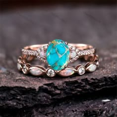 a ring with an oval turquoise stone surrounded by white and yellow opalite stones