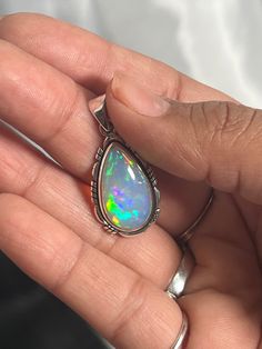 Embrace your best self with these magical Ethiopian Opal pendants. The brilliant southwest-styled setting and glowing teardrop stone make this exquisite pendant an excellent statement piece. Opals have been revered by many cultures for their unique mystical beauty and the belief that they protect against negative energy and soothe sadness. This lustrous pendant adds a touch of splendor to any outfit with its fiery hues. You won't be disappointed. Materials: .925 Sterling Silver, Ethiopian Opal A Mystical Teardrop Gemstone Jewelry, Opal Teardrop Jewelry With Natural Stones, Traditional Teardrop Large Pendant Jewelry, Mystical Teardrop Sterling Silver Jewelry, Multicolor Teardrop Spiritual Jewelry, Unique Teardrop Stone-set Jewelry, Unique Teardrop Stone Setting Jewelry, Unique Teardrop Shaped Jewelry With Stone Setting, Bohemian Teardrop Gemstone Pendant