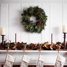 a mantle with stockings and christmas decorations on it