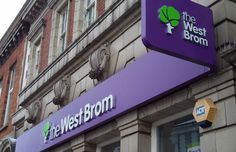 the west brom sign is purple and green on the building's front door