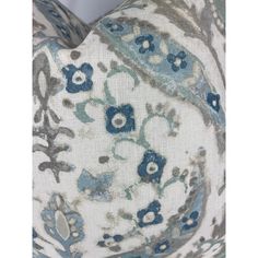 a blue and white pillow with flowers on it's side, in the shape of a circle