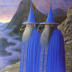 two wizard like men with long beards and blue robes are standing in front of a mountain