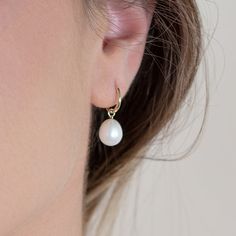 lightweight and graceful, our Paradise earrings are the ideal blend of quiet luxury and approachability. these elegant, 14kt solid gold huggie hoops are the perfect choice for any occasion. the delicate hoops are adorned with a genuine freshwater pearl, creating an air of sophistication and modernity. it is sure to become a timeless staple in your jewelry collection. the best part? since we love versatility, the pearl charm can be removed for a minimal look. you now have the perfect pair of ever Delicate Huggie Pearl Earrings With Charm, Hypoallergenic Yellow Gold Huggie Pearl Earrings, Classic 14k Gold Filled Huggie Pearl Earrings, Elegant Teardrop Huggie Earrings With Lever Back, 14k Yellow Gold-filled Huggie Pearl Earrings, Yellow Gold 14k Gold-filled Huggie Pearl Earrings, Elegant 14k Gold Filled Teardrop Huggie Earrings, Elegant Teardrop Huggie Earrings In 14k Gold, Everyday Teardrop Huggie Earrings With Pearl Drop