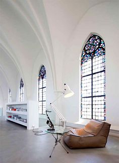 an empty room with stained glass windows and a bean bag chair in the foreground