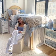 a woman sitting on a bed in a bedroom