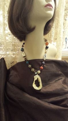 "One strand beaded faceted necklace with center drop. The drop measures 2 1/2\" long and about 1 1/2\" wide. The necklace measures 20\" long. Some of the variety of stones used in this necklace is jasper, onyx, shell coral. The drop is the inside of a druzy. Looks great with lots of outfits. If you like it \" pin it \" or share on Facebook." Of Outfits, Pin It, Austin Tx, Druzy, Onyx, Looks Great, Austin, Statement Necklace, Beaded Necklace