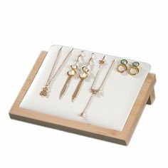 a wooden tray with six pairs of earrings on it