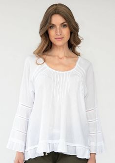 We're loving the look of this top. It's made of soft Peruvian cotton embellished with tonal crochet trims, subtle embroidery, and tiny pleats as a nice accent. The A-shape silhouette gives you a Bohemian look. Peasant Style Cotton Top With Relaxed Fit, Spring Cotton Blouse With Crochet Trim, Feminine Cotton Crochet Top With Crochet Trim, White Blouse With Cutwork Hem For Daywear, Feminine Cotton Embroidered Top For Daywear, Bohemian Relaxed Fit Top For Daywear, Cotton Peasant Top With Lace Trim For Daywear, Feminine Crochet Trim Tops For Daywear, Relaxed Fit Bohemian Top For Daywear